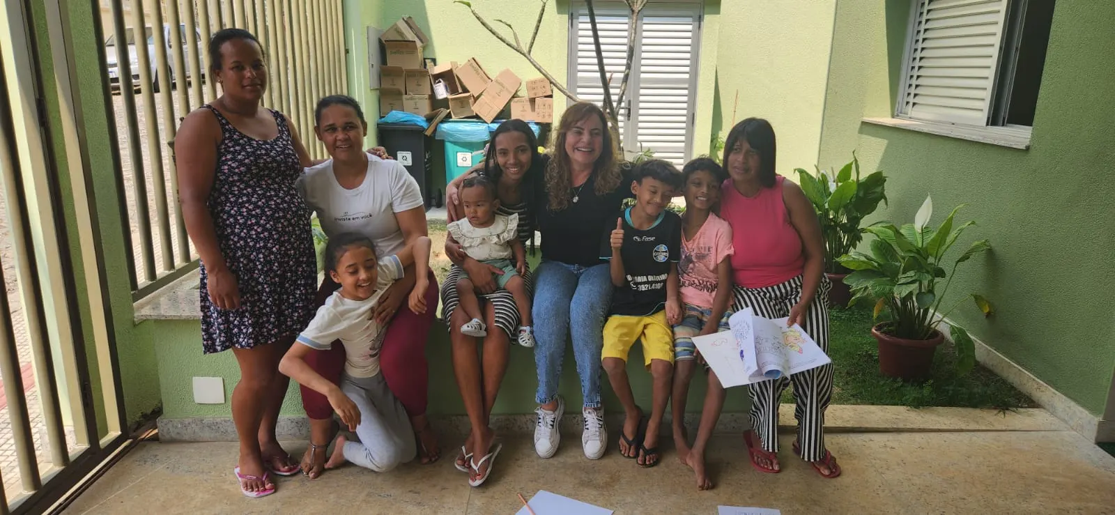 Mães, crianças e equipe no jardim da casa